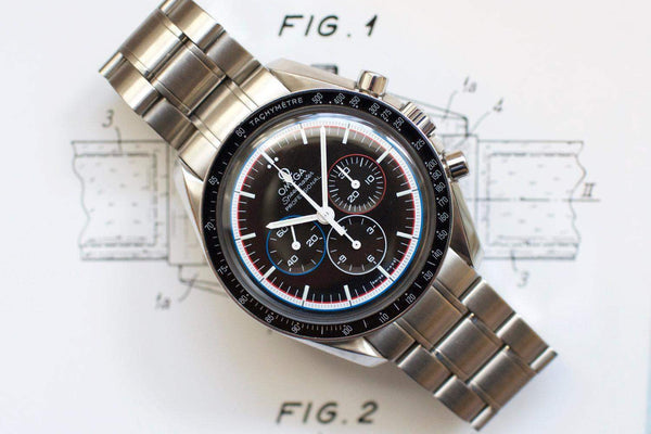 Stainless steel chronograph watch with black dial, red and blue accents, and tachymeter bezel