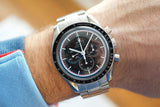 Omega Speedmaster Professional chronograph with black dial and tachymeter bezel on wrist