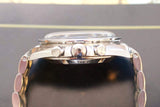 Close-up side view of stainless steel chronograph watch with pushers and bracelet