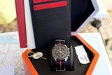 Luxury Swiss chronograph watch with black and orange strap in display box with documents