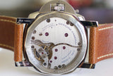 Close-up of Panerai watch case back with visible movement and brown leather strap