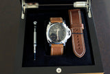 Panerai Luminor watch with brown leather strap, spare strap, and tool in presentation box