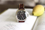 Luxury Panerai Luminor Marina wristwatch with brown leather strap on open book
