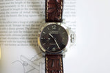 Luxury Panerai Luminor Marina watch with brown leather strap on open book background
