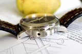 Close-up of a luxury Swiss watch with leather strap and brushed stainless steel case