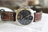 Luxury Panerai Luminor Marina watch with black dial and brown leather strap on book
