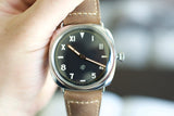 Close-up of a luxury Swiss-made watch with a black dial and brown leather strap