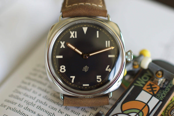 Luxury Swiss watch with black dial, mixed numerals, tan leather strap, close-up shot