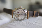 Close-up of luxury Swiss watch with visible mechanical movement and brown leather strap