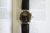 Radiomir Panerai wristwatch with black leather strap displayed on an open book