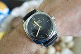 Luxury Panerai wristwatch with black dial and leather strap on wrist.