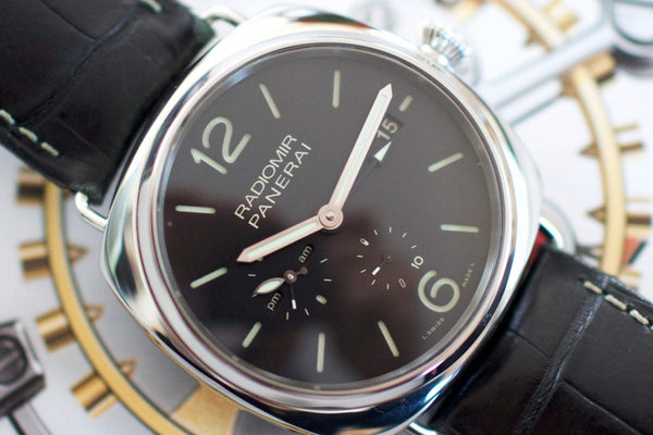 Close-up of Swiss luxury watch with black dial, silver markers, and black leather strap