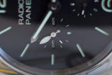 Close-up of luxury Swiss watch dial with luminous hands, GMT subdial, and power reserve indicator.