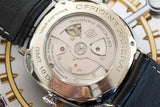 Close-up of a luxury watch back with visible automatic movement, stainless steel case, GMT 10 Days engraving, and black leather strap.