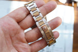 Close-up of a luxury stainless steel watch bracelet with a crown logo on the clasp.
