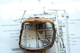 Close-up of a luxury gold watch resting on a technical watch blueprint drawing.