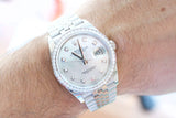 Rolex Datejust luxury watch with diamond bezel and silver dial on a wrist
