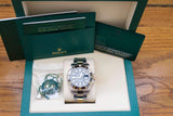 Rolex Submariner watch with original green box, warranty booklet, and guarantee card.
