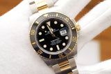 Two-tone Rolex Submariner Date luxury watch with gold and steel bracelet on a white glove