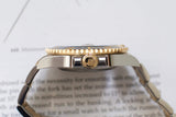 Close-up side view of a luxury gold and steel watch with a fluted bezel and crown logo.