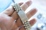 Close-up of a stainless steel luxury watch jubilee bracelet with a crown logo clasp.