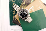 Rolex Submariner luxury watch with black dial and steel bracelet on vintage documents