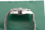 Side profile of a luxury stainless steel dive watch with a metal bracelet on a green background
