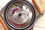 Close-up of a luxury Swiss watch movement with visible gears and a metal rotor