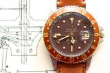 Vintage Rolex GMT-Master with a brown dial and bezel on a leather strap.