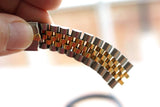 Close-up of a two-tone stainless steel and gold luxury watch bracelet link