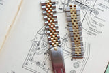 Two-tone gold and silver luxury watch bracelets resting on a technical drawing.