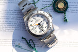Rolex Explorer II luxury watch with white dial and steel bracelet on a white background.