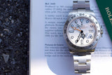 Rolex Explorer II luxury watch with white dial and steel bracelet on a document.