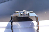 Side view of a luxury Swiss watch featuring a crown and stainless steel bracelet.