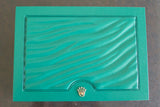 Green luxury watch box with textured lid and gold crown emblem