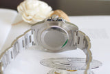 Close-up of stainless steel luxury watch caseback and bracelet on a light background
