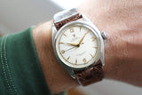 Vintage Rolex Oyster Perpetual Bubble Back watch with brown leather strap on wrist