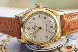 Vintage gold wristwatch with brown leather strap and classic analog dial