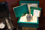 Rolex Submariner luxury watch in a green presentation box with warranty booklet
