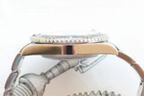 Side profile of a luxury gold and steel Swiss watch with a fluted bezel.
