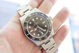 Rolex Submariner luxury watch with black dial and steel bracelet held in a hand