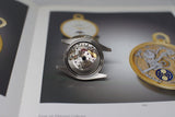 Close-up of luxury Swiss watch movement in stainless steel case on an open book
