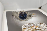 Stainless steel luxury watch with blue Roman numeral dial and date window on display