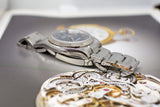 Stainless steel luxury watch with fluted bezel and bracelet, displayed on a watch magazine