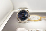Stainless steel luxury watch with blue dial and Roman numerals, date displayed at 3 o'clock