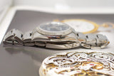 Close-up of a stainless steel luxury watch with visible bracelet and intricate gear mechanism