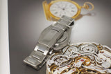Stainless steel Rolex Datejust 36mm watch with oyster bracelet on a watch movement background