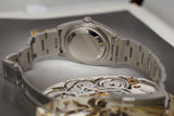 Stainless steel luxury watch caseback and bracelet, close-up on mechanical detail