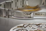 Close-up of stainless steel luxury watch bracelet clasp and watch movement gears.