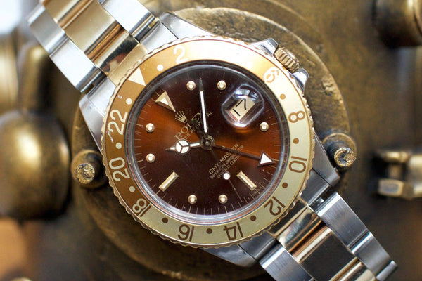 Vintage two-tone brown and gold GMT watch with date display and stainless steel bracelet